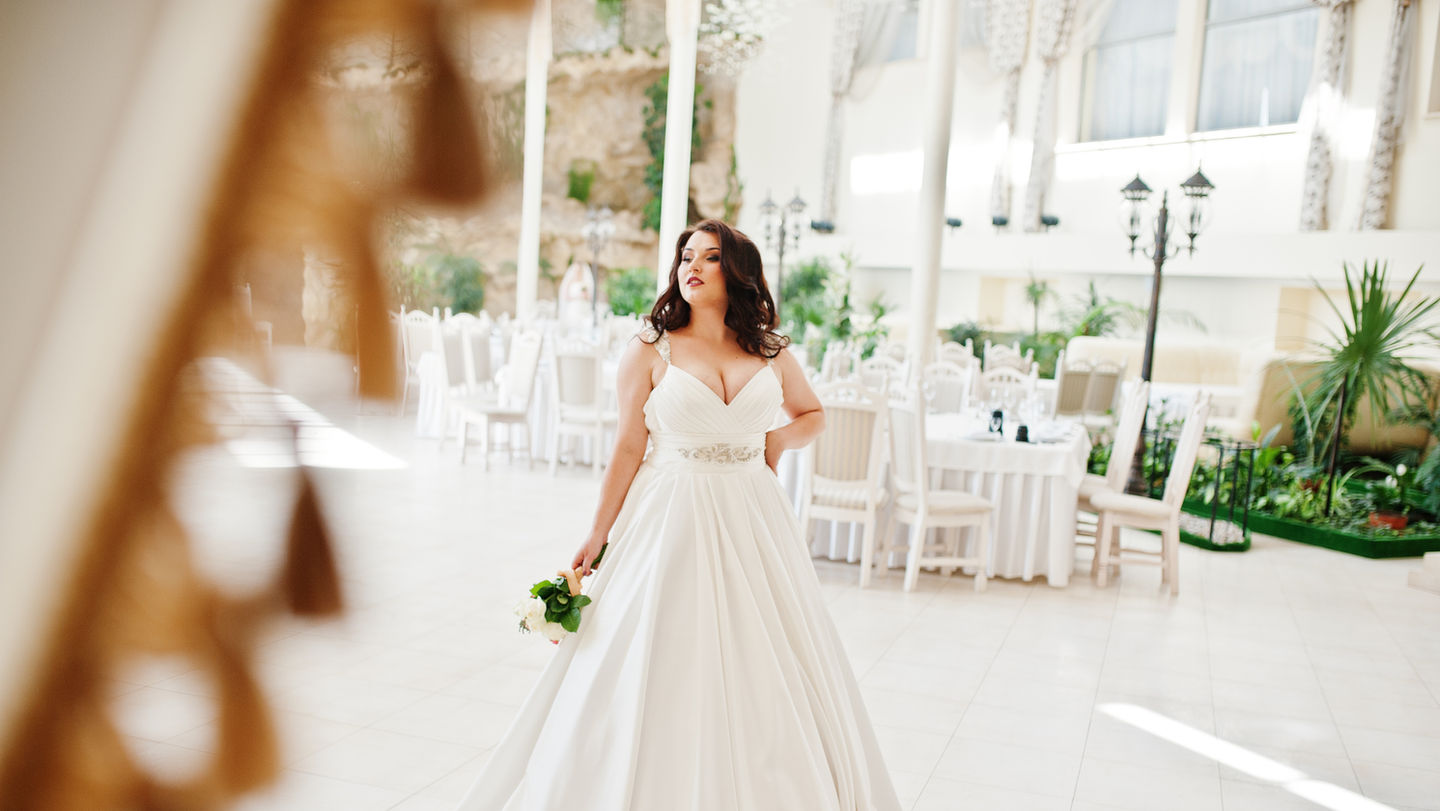 Plus size bride in a minimalist elegant satin wedding gown.