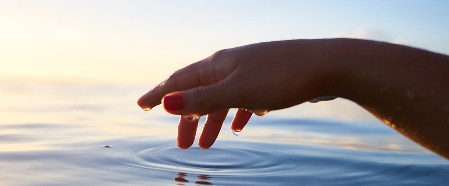 Hand touching calm water