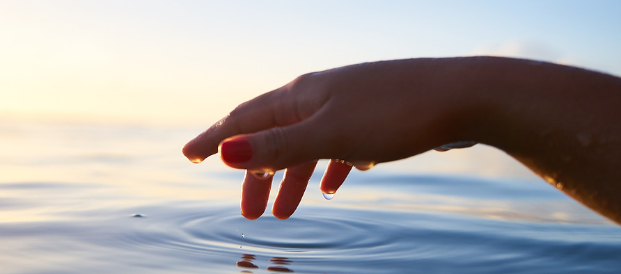 Hand touching calm water
