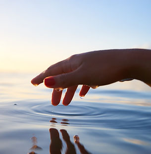Hand touching calm water