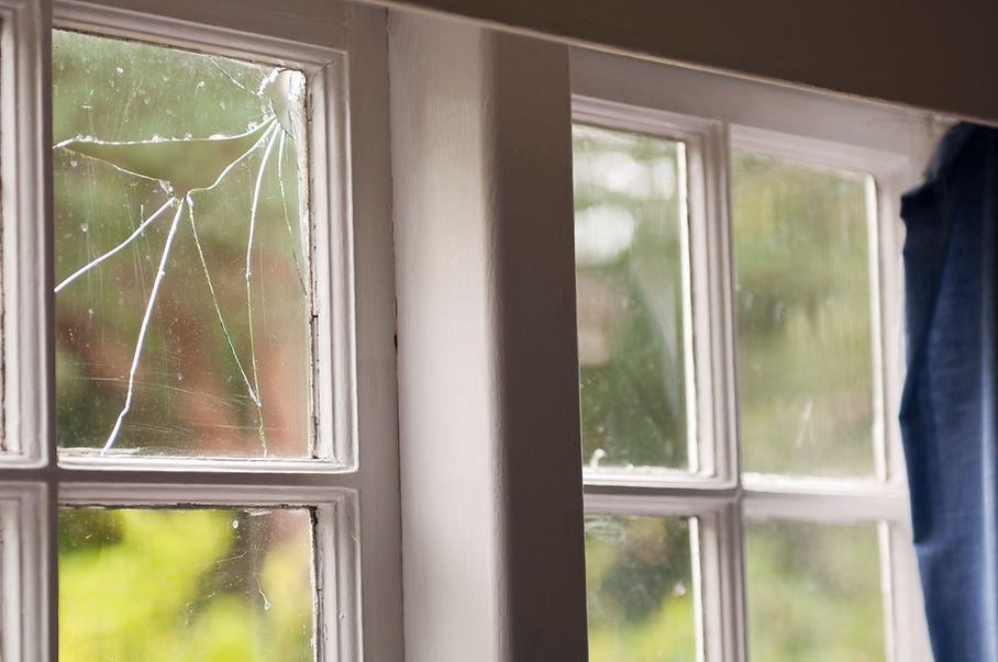 Horizontal image of a broken window pane in an old house