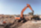 Excavator moving earth into a dump truck at a building site