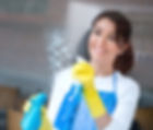 Woman housekeeping cleaning the windows of a house