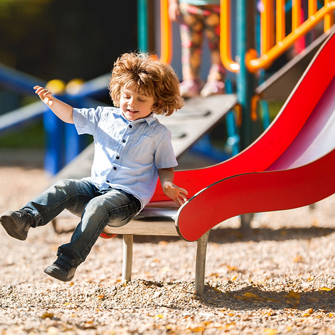 Child sliding down playground slide