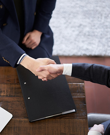 Close-up of a professional handshake over a financial document, representing client trust and personalized consultation with DnA CPA’s and Advisors.