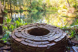 Red brick well in the middle of a pond
