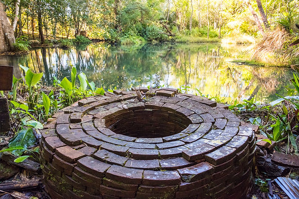Red brick well in the middle of a pond