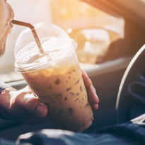 A man drinking coffee while driving