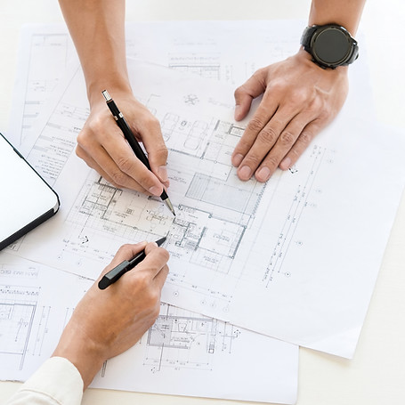 Two individuals discussing rescue plan blueprints at a table