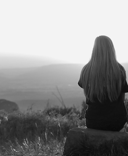 Femme face au coucher du soleil