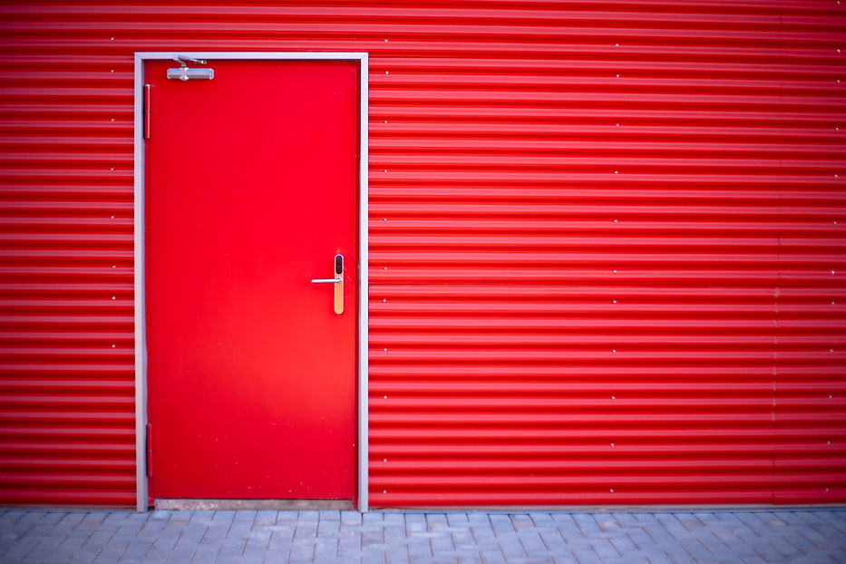 a red closed door in a red metal striped wall