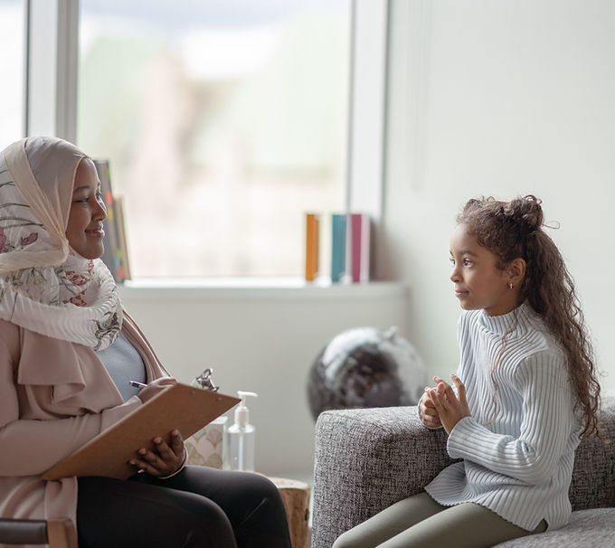 Female therapist smiling and talking to child client