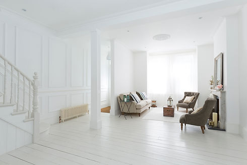 Elegant white living room with classic wall panelling and neutral furniture