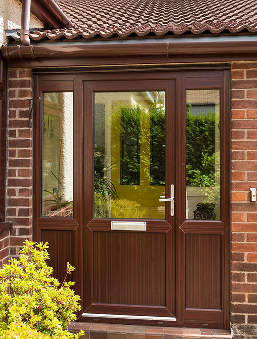 Close-up of a dark brown wood grain composite door handle and frame with glass panels
