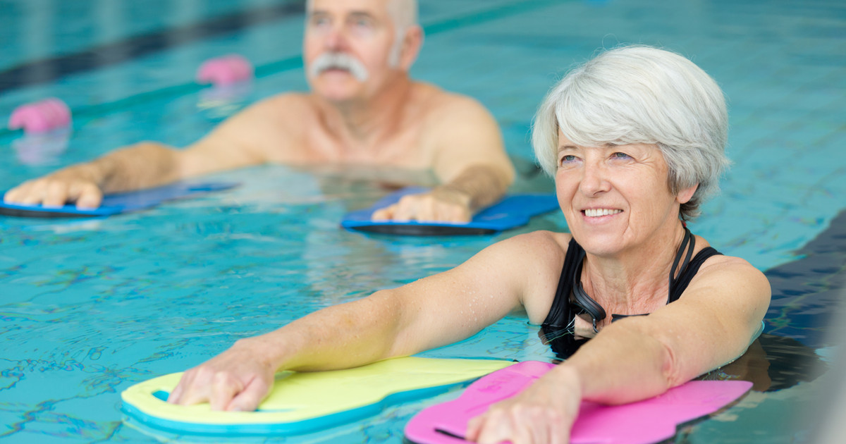 A person participating in a supervised hydrotherapy session in a warm therapy pool, demonstrating gentle movement and exercise in water.