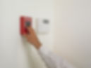 close-up image of a person's hand while activating a fire alarm