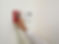 A person reaching to activate a red fire alarm on a wall