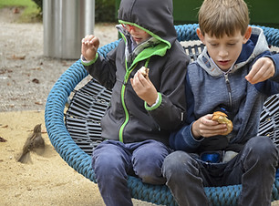Children sitting on playground swing