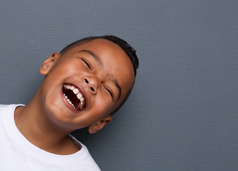 Young boy smiling, tilting to the side