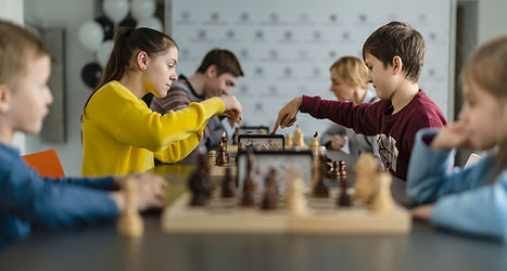 Children playing chess with one tapping the clock