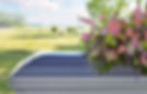 Closeup of a casket and floral funeral spray with a rural scene in the distance