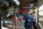 Mechanic with clipboard explaining repairs to a customer
