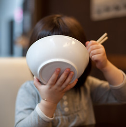 ご飯をかきこむ子供