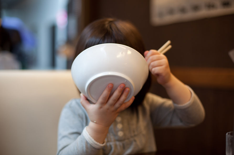 ご飯をかきこむ子供