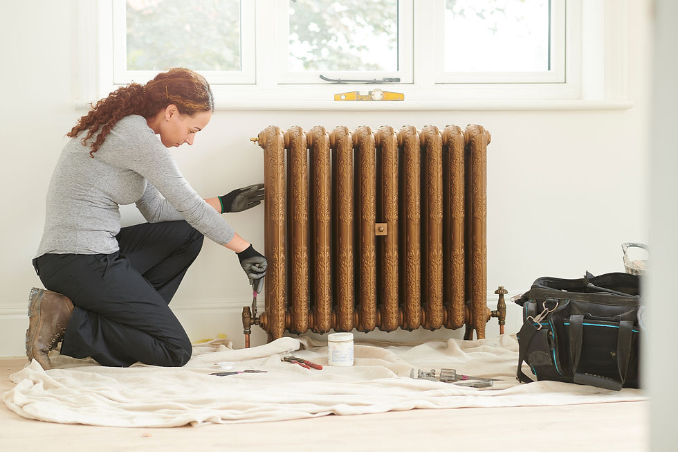 Female plumber installing an ornate bronze cast iron radiator
