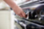 person turning on a gas cooker