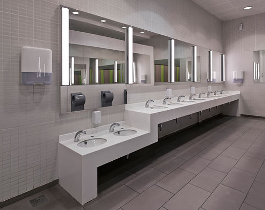 Modern restroom with a long row of white sinks and mirrors