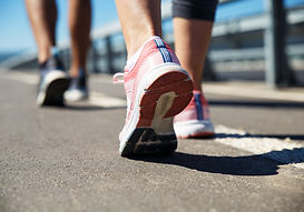 A person tying their walking shoes at the front door, with a small smile, ready to head out for a walk.