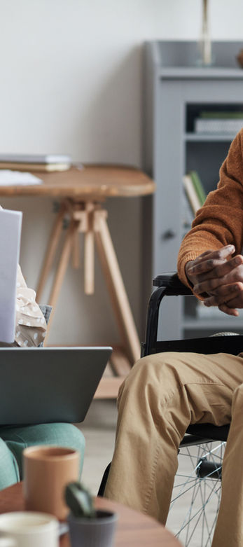 Woman reviewing resume documents with a man in wheelchair