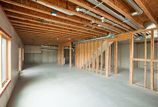 "An unfinished walk-out basement in a large two-story or ranch house. Basements are often 