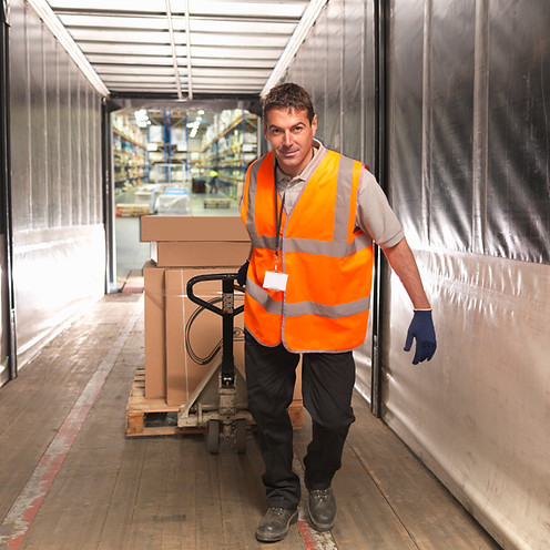 Worker loads truck with pallet truck