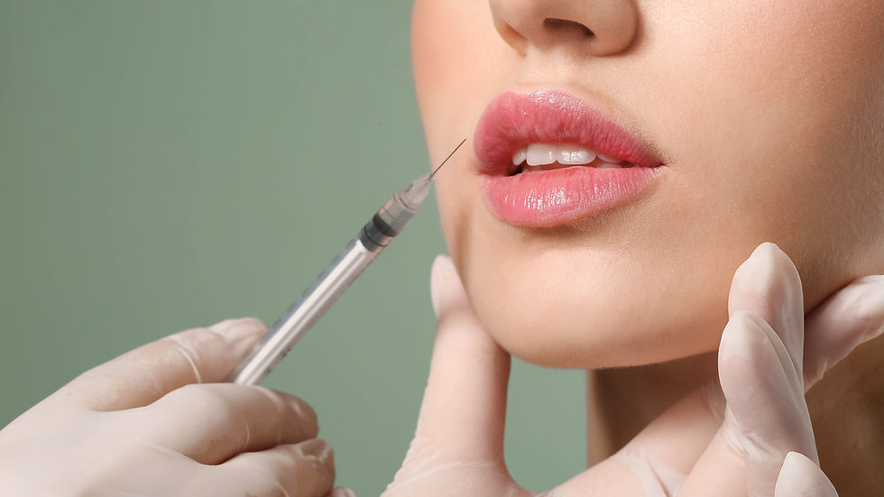 Close-up of a woman's lips as a gloved hand holds a botox syringe near them. The background is a soft green, creating a clinical setting.