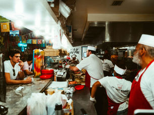 Restaurant employees working together during a busy shift, illustrating effective labor management and customer service for small business success.