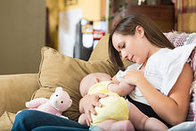 Mother breastfeeding baby on sofa