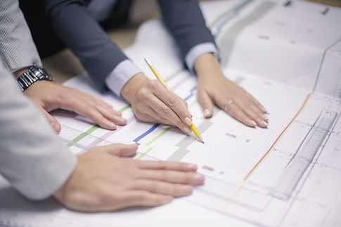 Two people discussing plans on charts