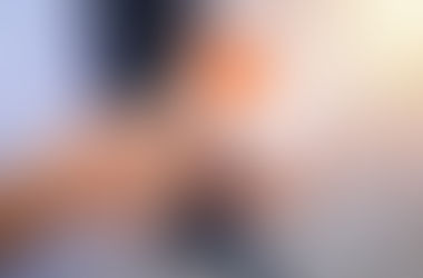 Hands holding a thank-you gift in a white gift box with a red heart, wrapped in twine. Background is softly blurred, conveying a warm, thoughtful mood.