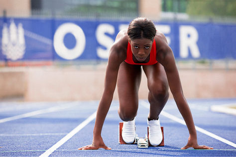 A woman prepares to start on the running track.