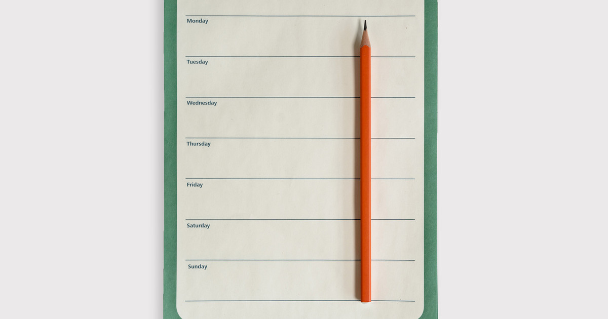 A person reviewing a simple weekly exercise plan while preparing for a walk, demonstrating how planning and consistency support long-term recovery.