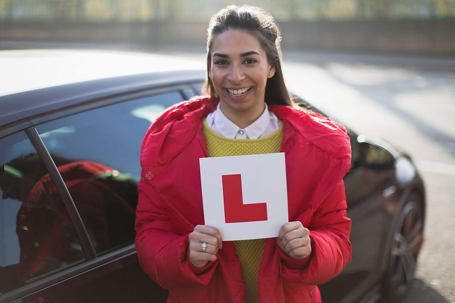 A happy young woman holding a learner permit