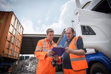 two workers looking at clipboard in scrap yard