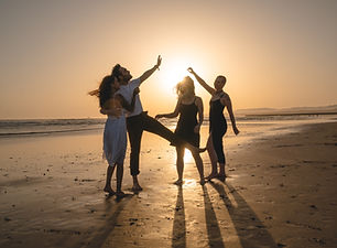 Dans på stranden i solnedgången