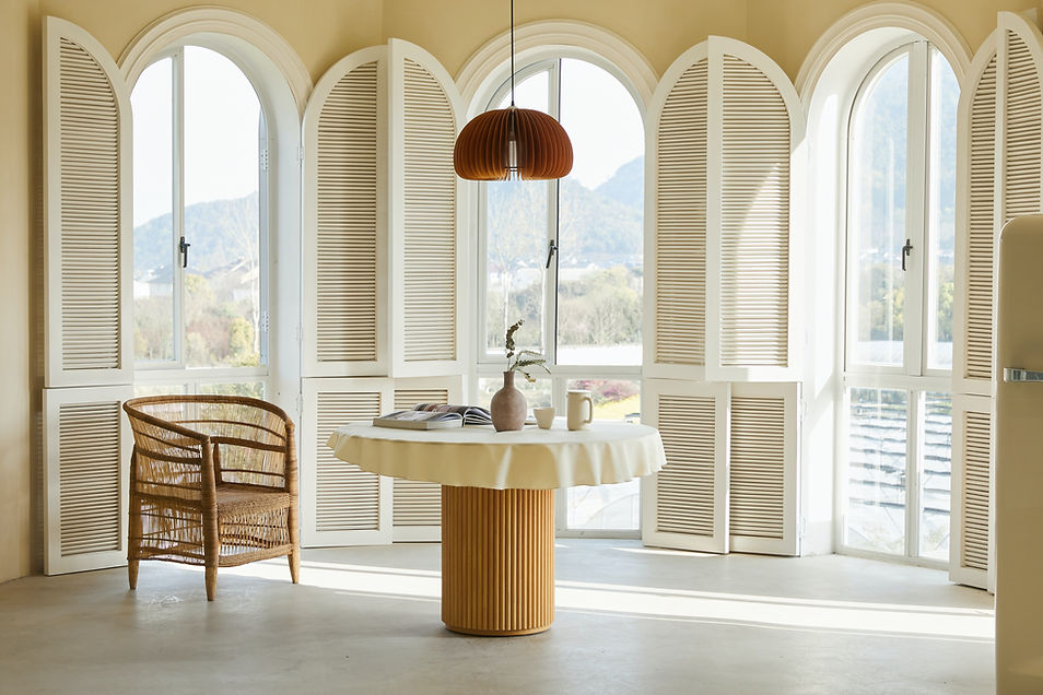 White cafe-style window shutters covering lower half of window in a dining space