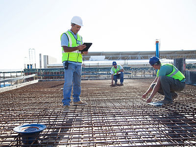 Construction workers arranging rebar at construction site