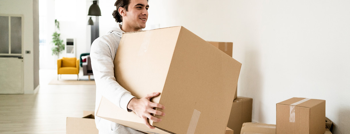 professional man carrying boxes inside modern self storage facility
