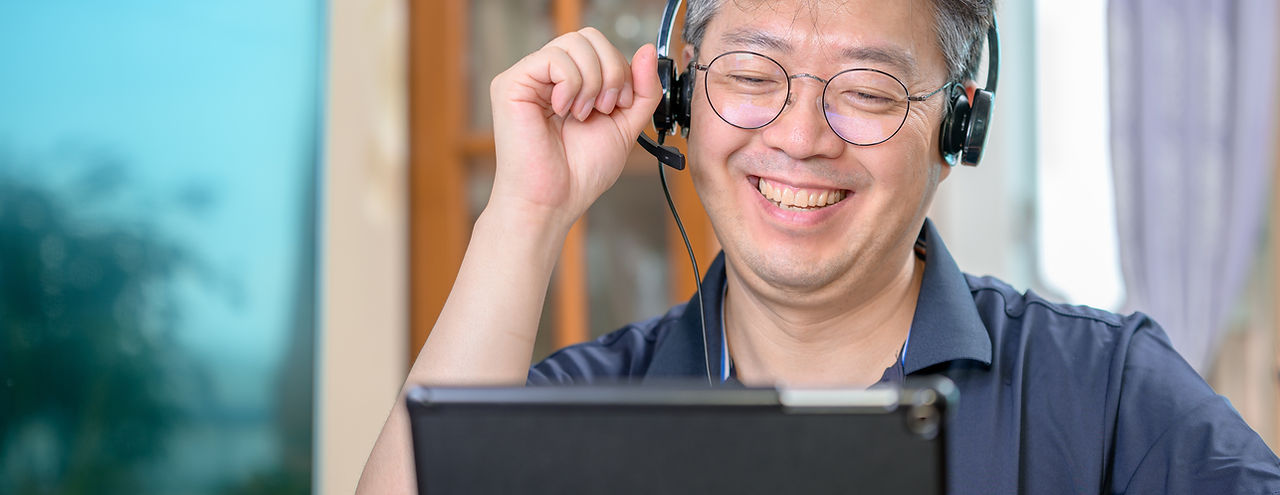 Smiling Person Talking through Headphones