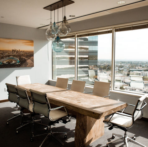 Toronto home office renovation featuring a custom wood boardroom table, leather seating, and professional lighting fixtures.